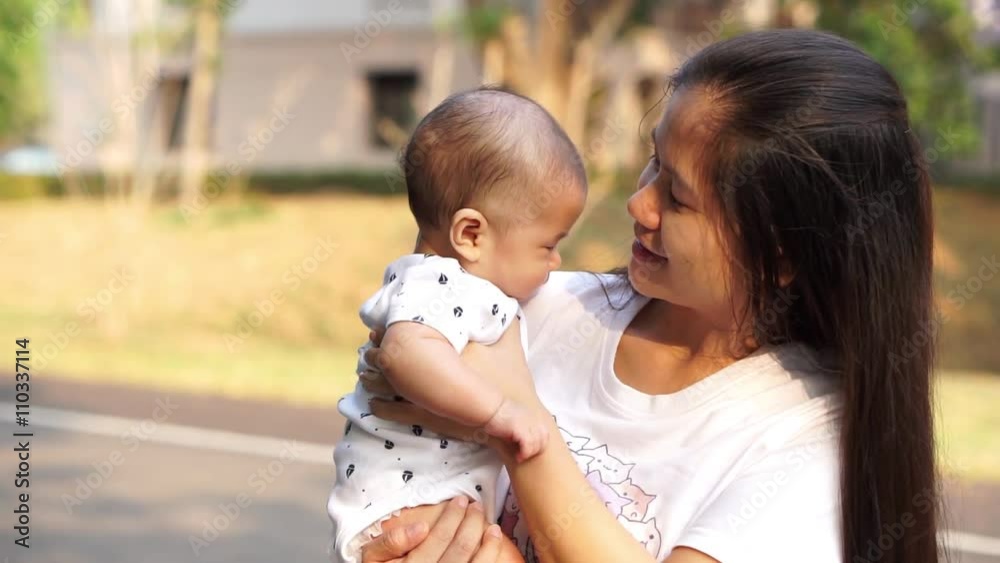Asian mother holding a sleepy baby Asian mother holding a sleepy baby