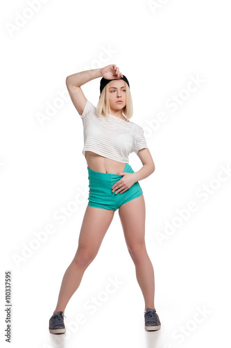 Pretty young woman wearing shorts and tshirt posing isolated