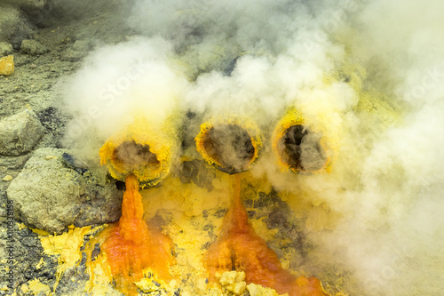 Molten sulfur dripping from pipes at Kawah Ijen volcano, East Java, Indonesia. photo