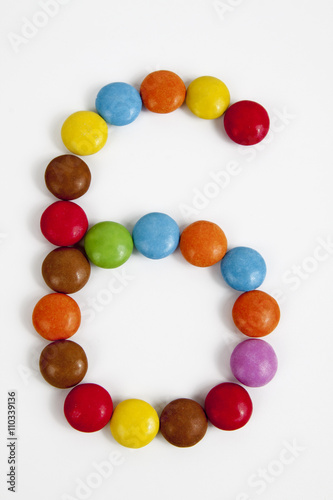 Il numero sei formato da coloratissimi confetti di cioccolato.