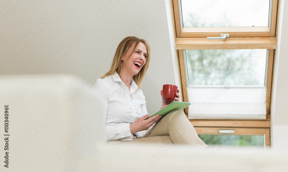Middle-age woman using digital tablet while sitting at startup c Middle-age woman using digital tablet while sitting at startup c