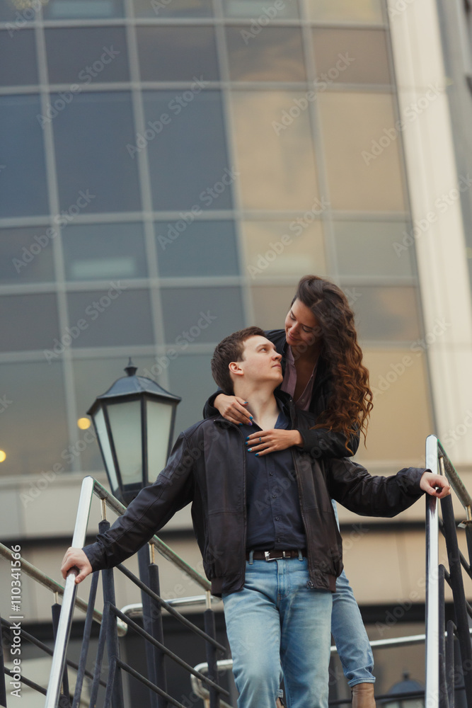 Young couple hugging while sitting on staircase Young couple hugging while sitting on staircase