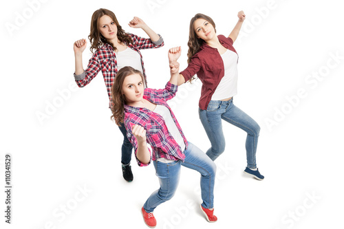 three young women dancing over white background 