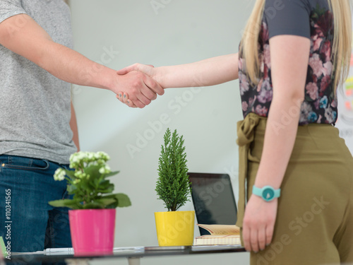 business man and business woman shaking hands closing a deal