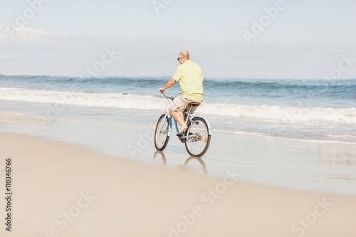 Smiling senior man riding bike