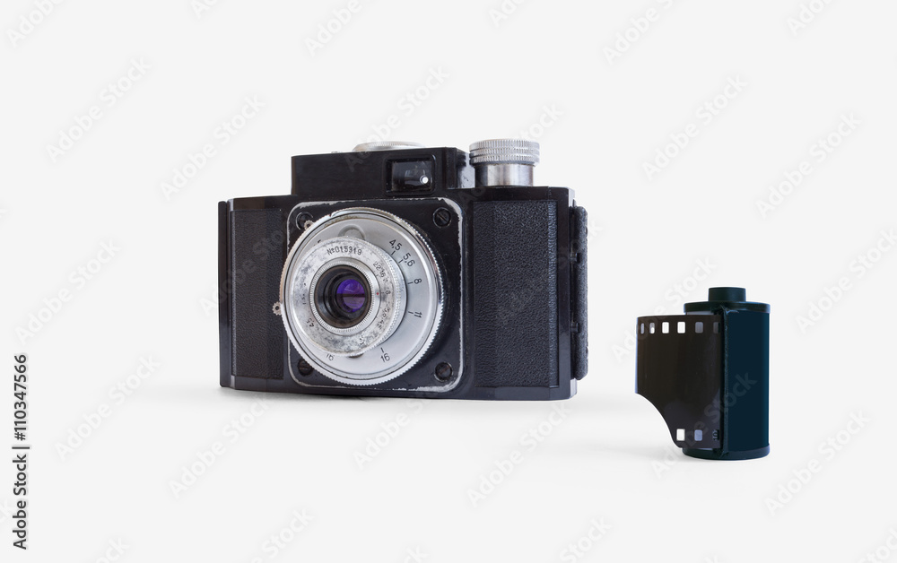 Old compact film camera and film roll isolated on white