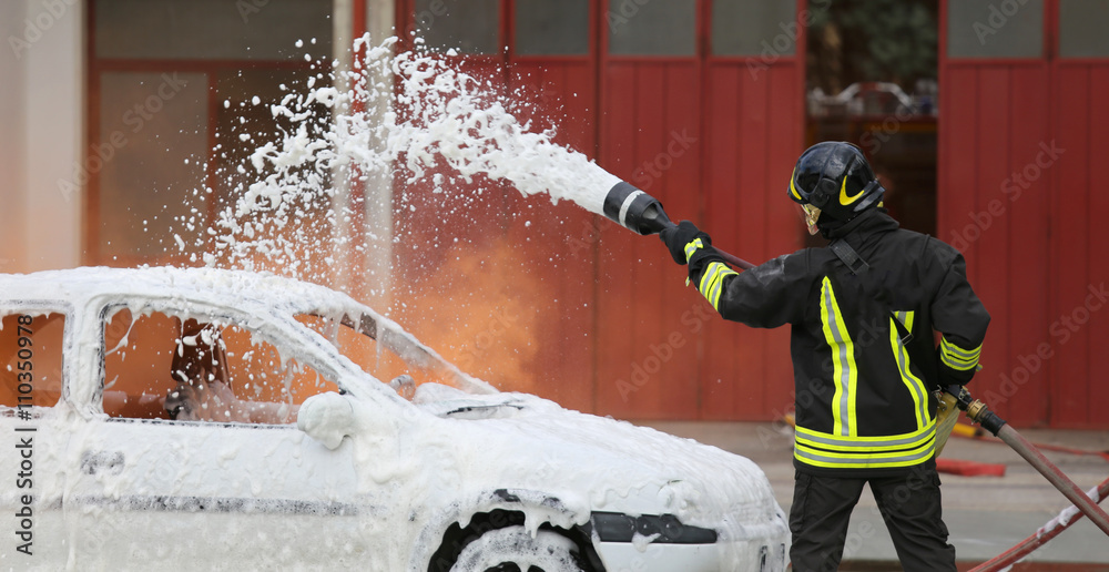 Obraz premium firefighters during exercise to extinguish a fire in a car