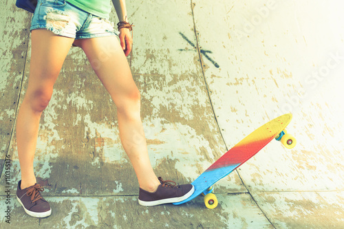 Close-up skateboarder girl with skateboard outdoor at skatepark photo