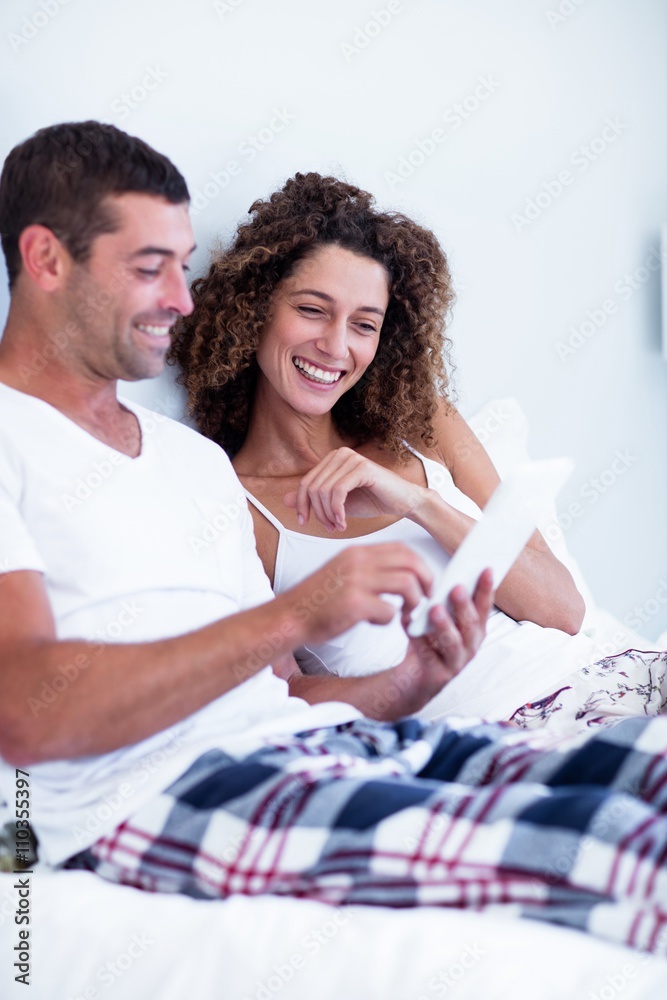 Happy couple using digital tablet on bed Happy couple using digital tablet on bed