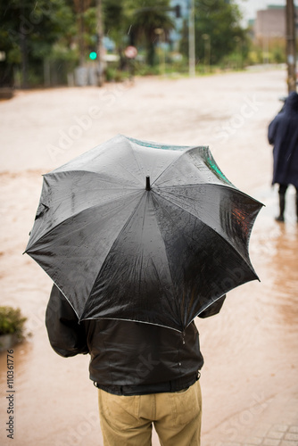 Man holding an umbrella during a flood at Santiago de Chile