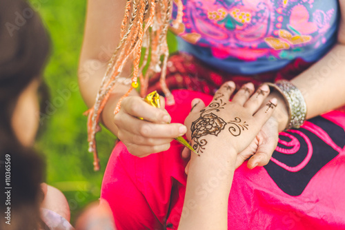 Picture of human hand being decorated with henna tattoo, mehendi © sushytska