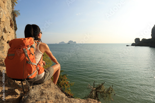 young woman hiker enjoy the view on sunset seaside