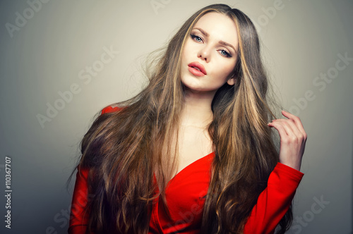 Beautiful young and emotional caucasian woman model with deep blue eyes and sensitive lips posing at studio in the light flashes. Great long natural hair.