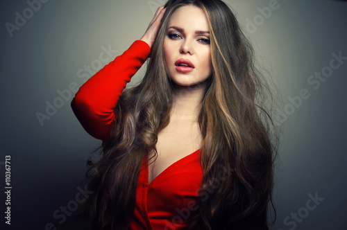 Beautiful young and sexy caucasian woman model with deep blue eyes and sensitive lips posing at studio in the light flashes. Great long natural hair.