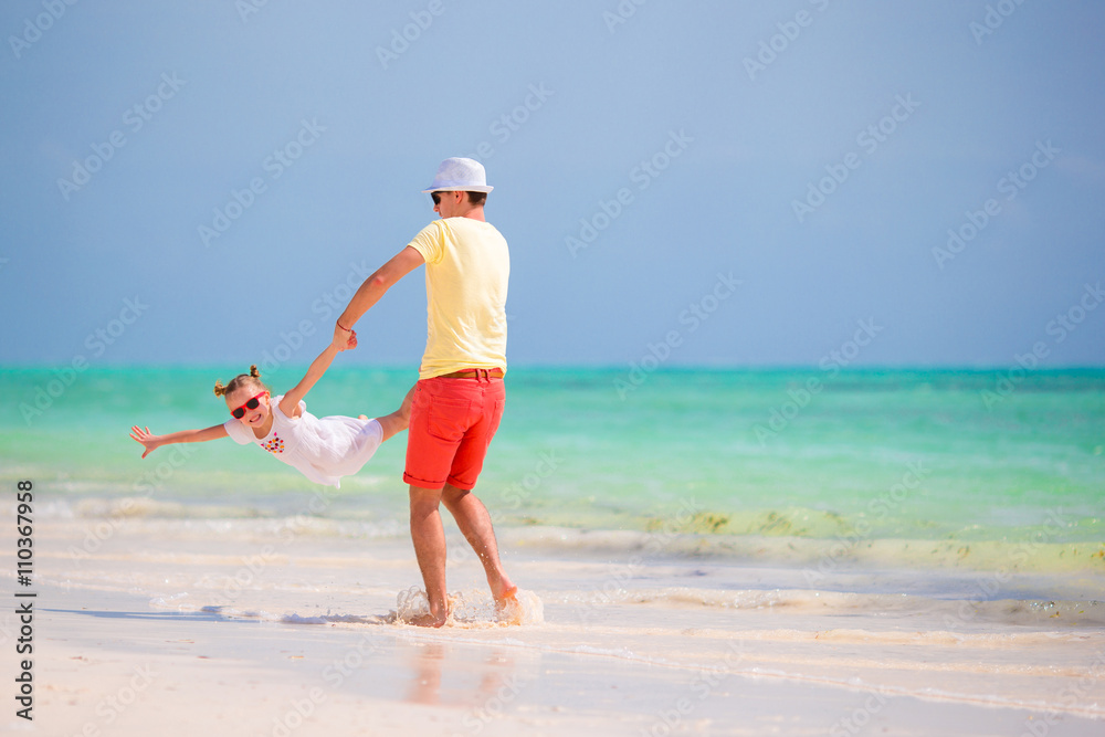 Happy father and his adorable little daughter at tropical beach having fun Happy father and his adorable little daughter at tropical beach having fun