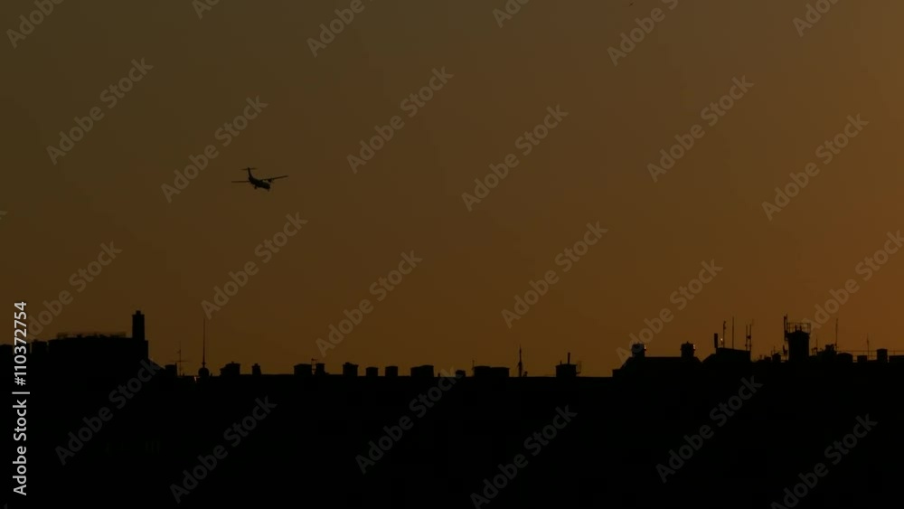 STOCKHOLM, SWEDEN, MAY 2016: An airplane landing in airport behind the city buildings during sunset STOCKHOLM, SWEDEN, MAY 2016: An airplane landing in airport behind the city buildings during sunset