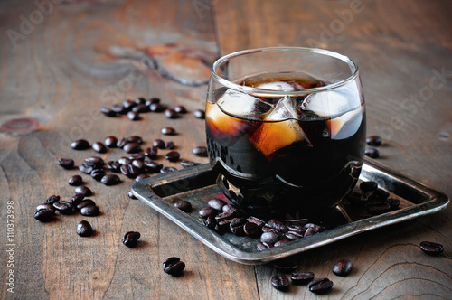 Kahlua liqueur in glasses with coffee beans on a wooden background, selective focus