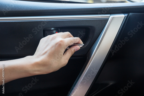 Woman driver pressing button locking and unlocking doors in car. © powerbeephoto