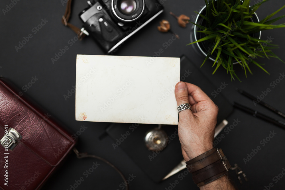 Obraz premium Photo in the hand, vintage style, on the black table