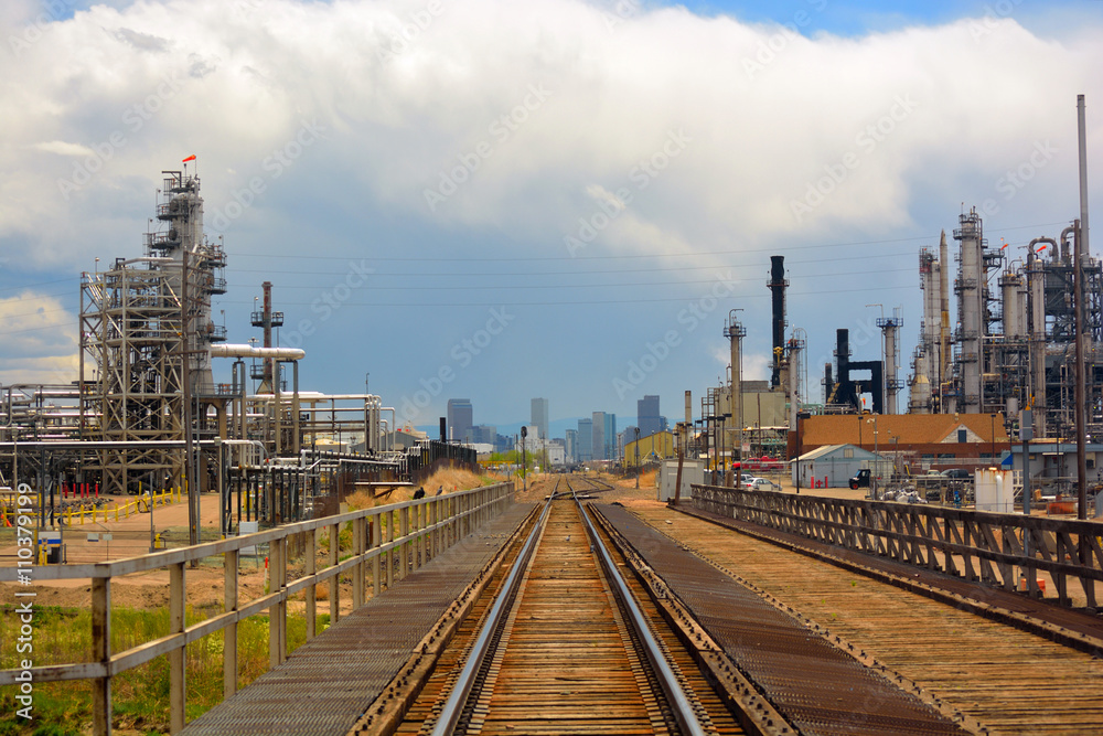 Oil and Gas Refinery Distillation Towers with Railroad Tracks and a Distant City