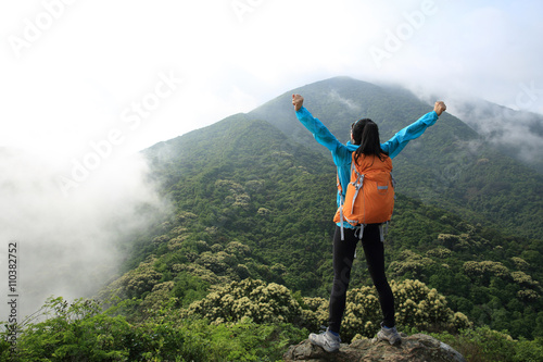 Fototapeta Naklejka Na Ścianę i Meble -  cheering woman hiker open arms on mountain peak
