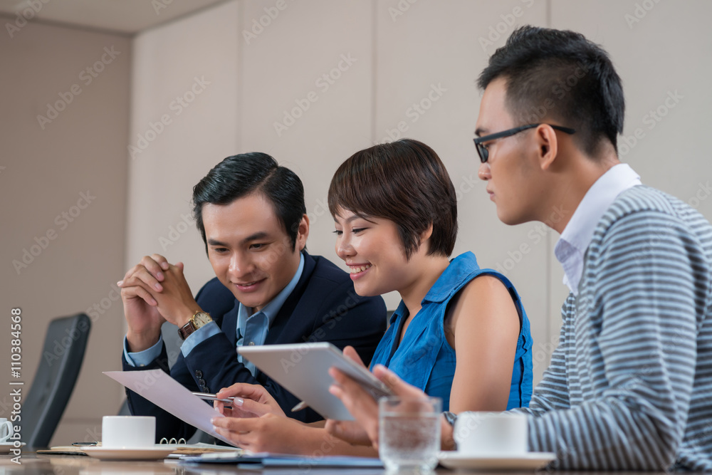 Vietnamese business team analyzing charts and graphs Vietnamese business team analyzing charts and graphs