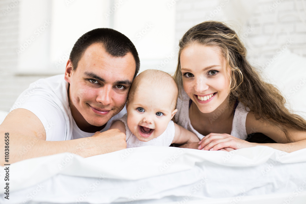 Mother and father with little baby in a bed Mother and father with little baby in a bed