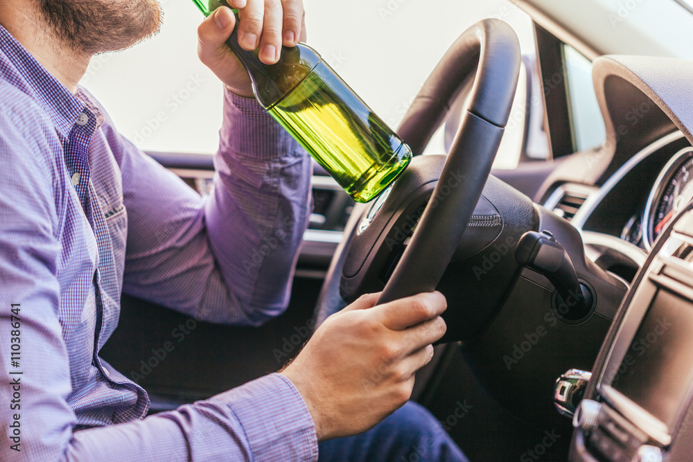 Naklejka premium man drinking alcohol while driving the car