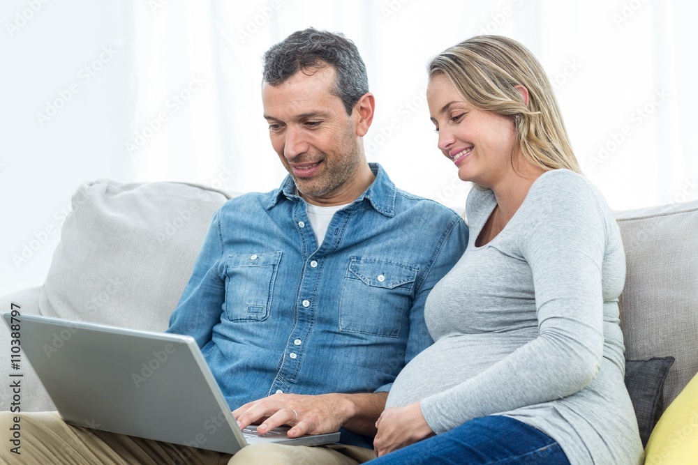 Couple sitting together and using laptop Couple sitting together and using laptop