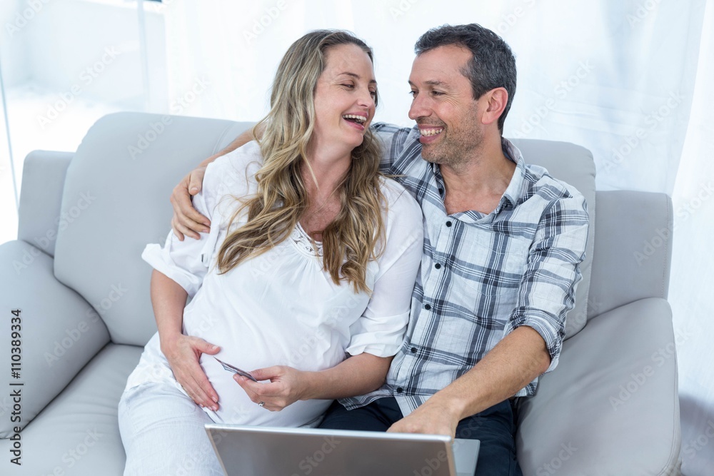 Expecting couple sitting on sofa Expecting couple sitting on sofa