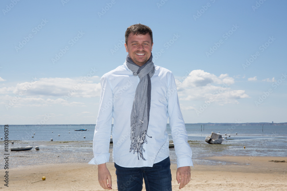 Happy gorgeous handsome man with blue shirt posing at the Sea Happy gorgeous handsome man with blue shirt posing at the Sea