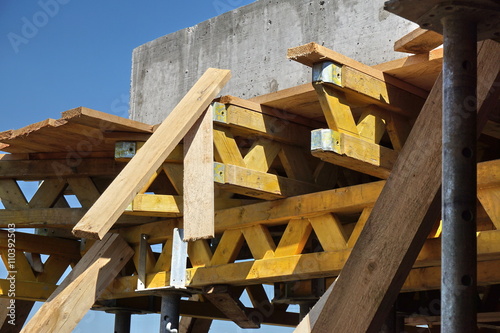 Heavy wooden beams and girders supporting construction of a concrete floor in the newly constructed building