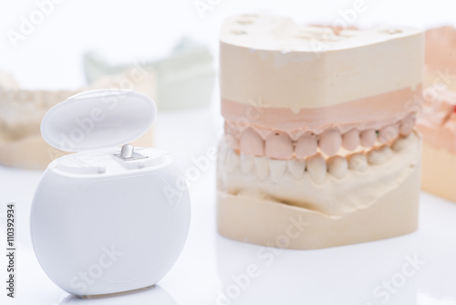 Teeth molds with dental floss on a bright white table photo