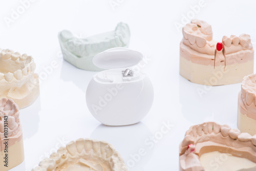 Teeth molds with dental floss on a bright white table photo