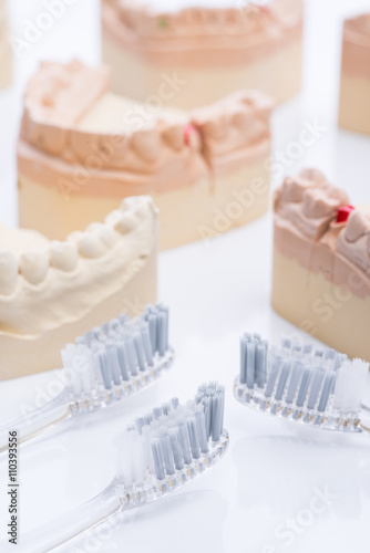 Teeth molds with toothbrush on a bright white table photo