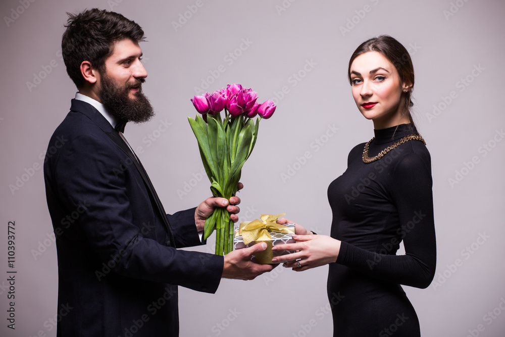 Young man give a gift for his girlfriend and tulips bucket on white background Young man give a gift for his girlfriend and tulips bucket on white background