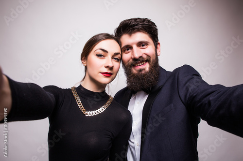 Young couple take selfie from hands on grey background