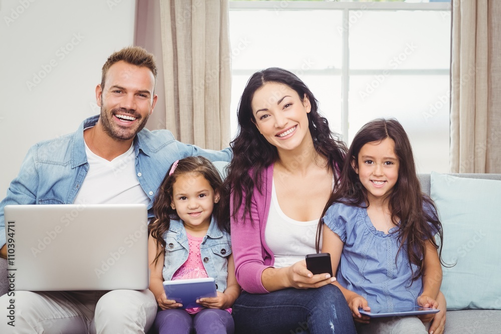 Happy family using modern technologies while sitting on sofa Happy family using modern technologies while sitting on sofa