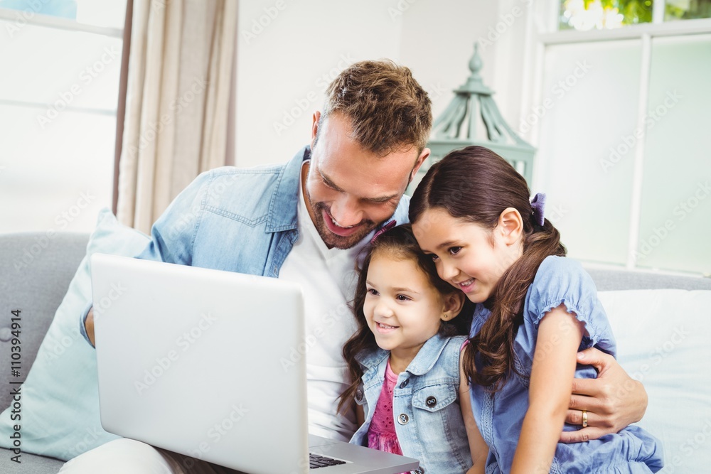 © WavebreakmediaMicro - Father and daughters looking in laptop at home © WavebreakmediaMicro - Father and daughters looking in laptop at home