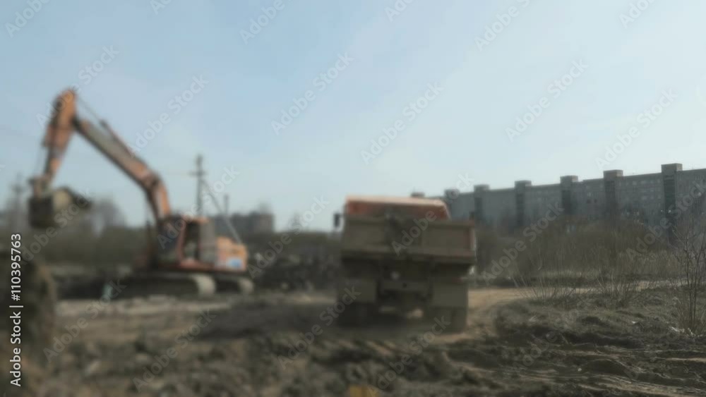 A excavator loading the clay into the dump truck A excavator loading the clay into the dump truck