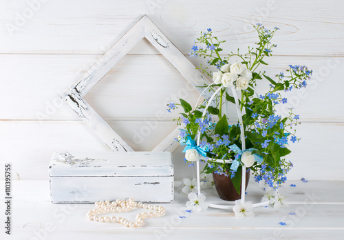 Forget-me-not flowers with birdcage and photo frame and casket w photo