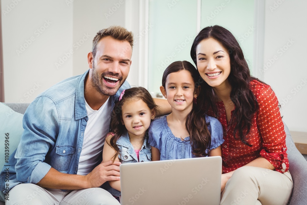 Portrait of family smiling and using laptop on sofa Portrait of family smiling and using laptop on sofa