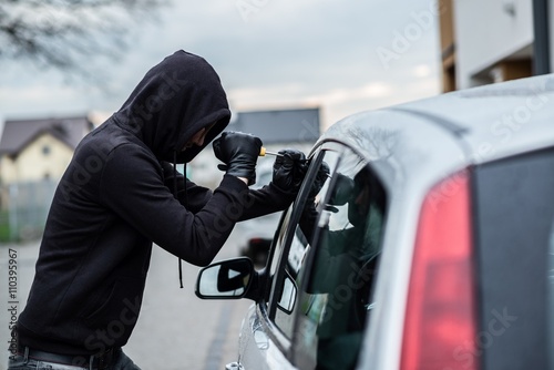 Obraz na płótnie Car thief trying to break into a car with a screwdriver. w salonie