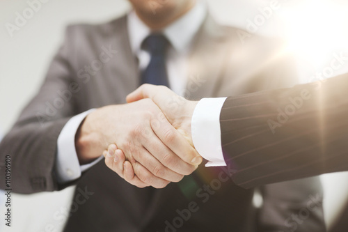 two businessmen shaking hands in office photo