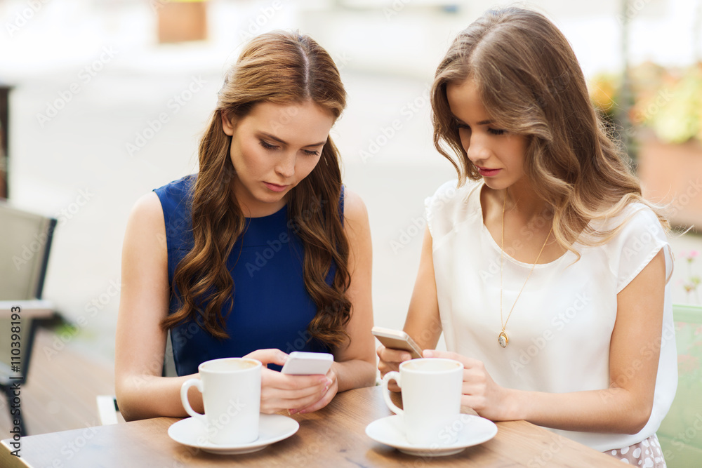 women with smartphones and coffee at outdoor cafe women with smartphones and coffee at outdoor cafe