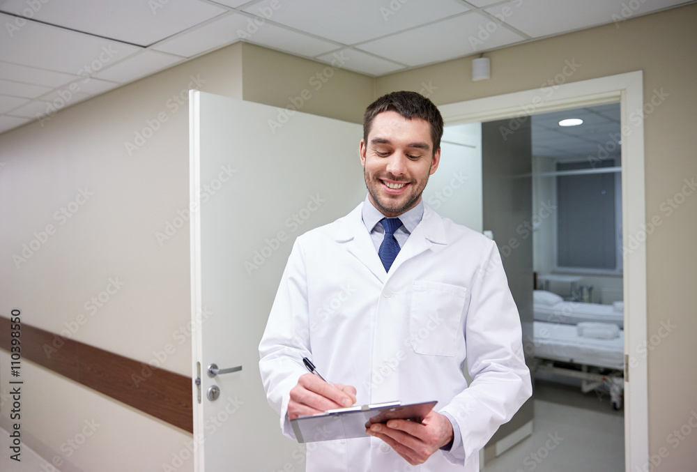 smiling doctor with clipboard at hospital
