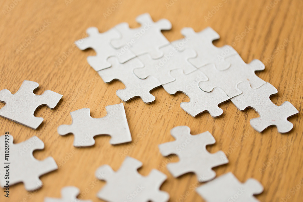 Fototapeta premium close up of puzzle pieces on wooden surface