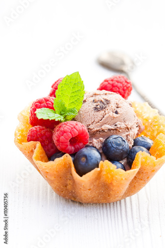 brandy snaps basket with chocolate ice cream and berries on whi