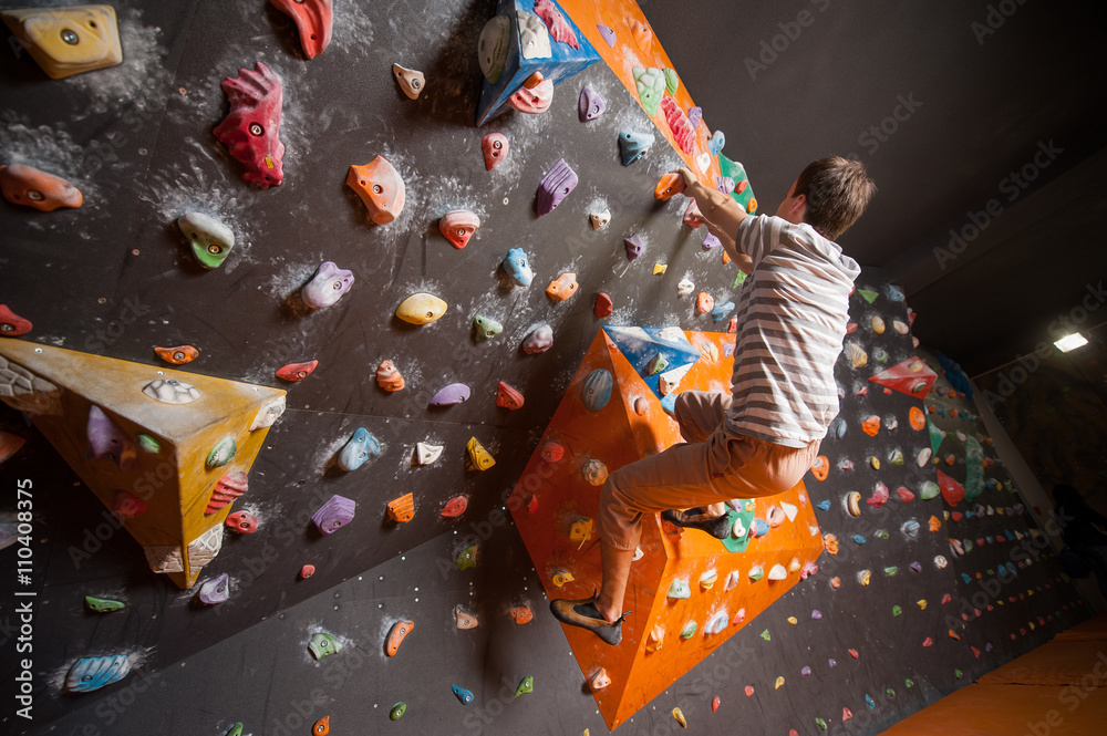 © anatoliy_gleb - Free climber young man climbing artificial boulder in gym, without special equipment © anatoliy_gleb - Free climber young man climbing artificial boulder in gym, without special equipment
