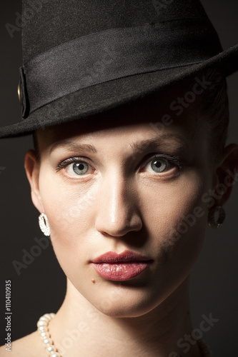 Portrait of a beautiful young model in black hat